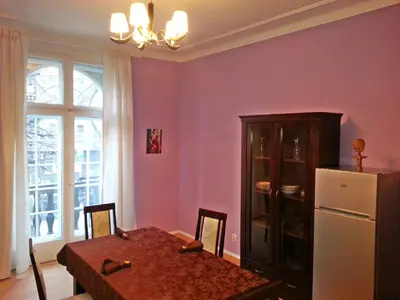 a dining room with a table and a refrigerator at Bel Lion Serviced Suites in Belgrade