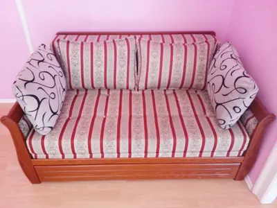 a couch with two pillows on it in a room at Bel Lion Serviced Suites in Belgrade