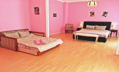 a room with two beds in a room with pink walls at Bel Lion Serviced Suites in Belgrade