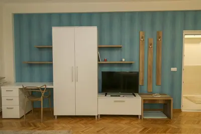 a white cabinet with a tv and a desk at Apartments Parlament in Belgrade