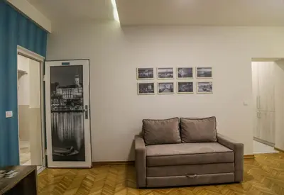 a living room with a chair and pictures on the wall at Apartments Parlament in Belgrade
