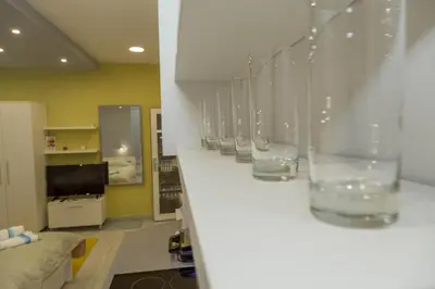 a row of glasses are lined up on a shelf at Apartments Parlament in Belgrade
