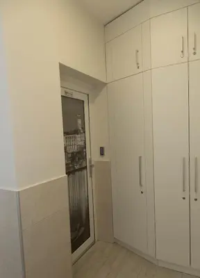 an empty room with white cabinets and a door at Apartments Parlament in Belgrade