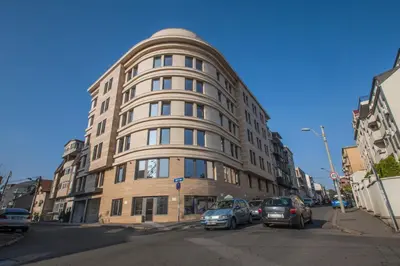 a tall building with cars parked in front of it at Abba Hotel in Belgrade