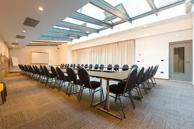 a conference room with a long table and chairs at Abba Hotel in Belgrade