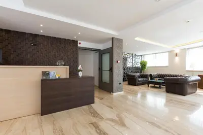 a lobby with leather furniture and a reception desk at Abba Hotel in Belgrade