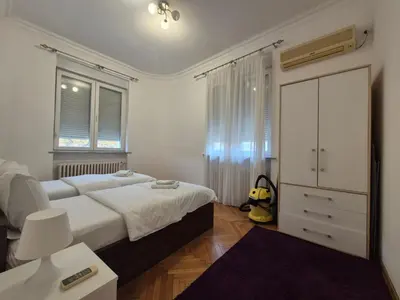 a bedroom with a bed and a dresser in it at Dositej 5 Apartment in Belgrade