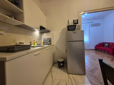 a kitchen with a refrigerator and a red couch at Dositej 5 Apartment in Belgrade