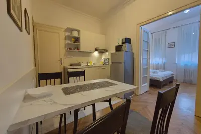 a kitchen and dining room with a table and a refrigerator at Dositej 5 Apartment in Belgrade