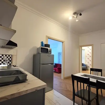 a kitchen with a refrigerator and a table with chairs at Dositej 5 Apartment in Belgrade