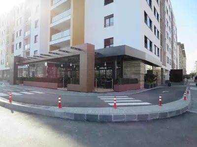 a building with a parking lot with orange traffic cones at Garden Apartment Sun City in Belgrade