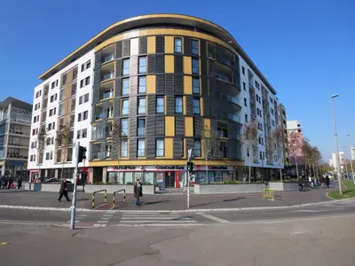 a building on a city street with people walking around it at Garden Apartment Sun City in Belgrade