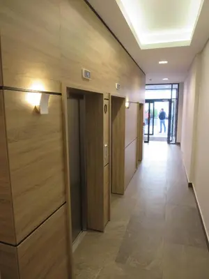 a hallway in a building with wooden walls and floors at Garden Apartment Sun City in Belgrade