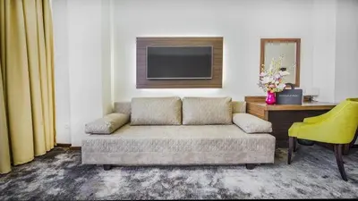 a living room with a couch and a television at Hotel Marshal Garni in Belgrade