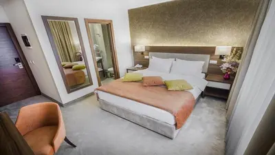 a bedroom with a large bed and a large mirror at Hotel Marshal Garni in Belgrade