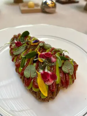 a piece of toast with vegetables on a white plate at Square Nine Hotel Belgrade-The Leading Hotels of The World in Belgrade