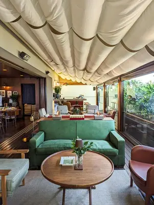 a living room with a green couch and a table at Square Nine Hotel Belgrade-The Leading Hotels of The World in Belgrade
