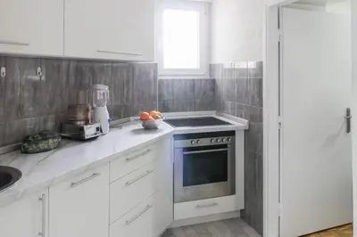 a kitchen with white cabinets and a stove top oven at Apartment La Bombonera in Belgrade
