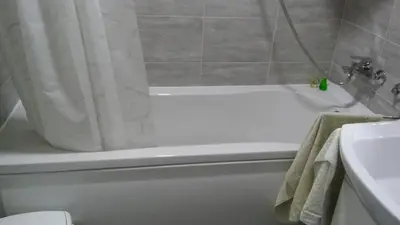 a bathroom with a white bath tub with a shower curtain at Apartment La Bombonera in Belgrade