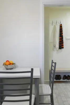 a kitchen with a table with two chairs and a bowl of fruit at Apartment La Bombonera in Belgrade