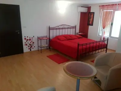 a bedroom with a red bed and a chair at B&B Queen in Belgrade