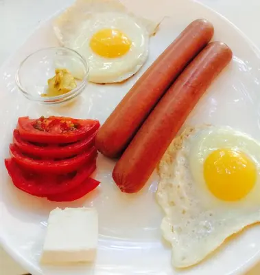 a plate of food with eggs sausage and peppers at B&B Queen in Belgrade