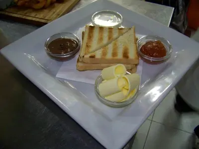 a white plate with bread and butter and condiments at B&B Queen in Belgrade