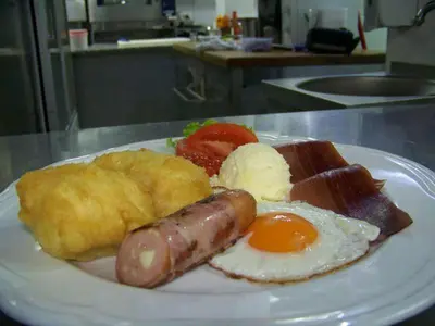 a plate of breakfast food with a sausage and eggs at B&B Queen in Belgrade