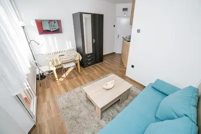 a living room with a blue couch and a table at City Panorama in Belgrade