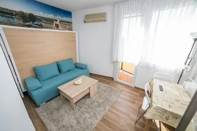a living room with a blue couch and a table at City Panorama in Belgrade