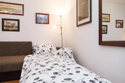a bedroom with a bed and a lamp and pictures on the wall at Modern Cozy Apartment in Belgrade