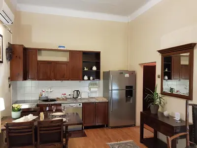 a kitchen with wooden cabinets and a stainless steel refrigerator at Classic Style Apartment in Belgrade