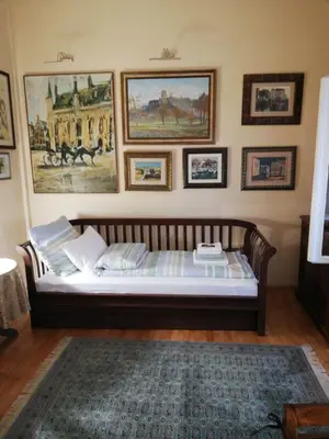 a bed in a room with pictures on the wall at Classic Style Apartment in Belgrade