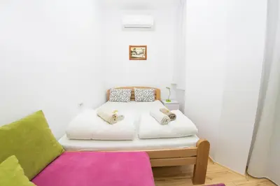 a small bedroom with a bed and a couch at Balkan-inn Apartment Terazije in Belgrade