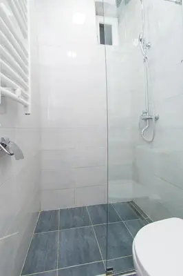 a bathroom with a glass shower with a toilet at Balkan-inn Apartment Terazije in Belgrade