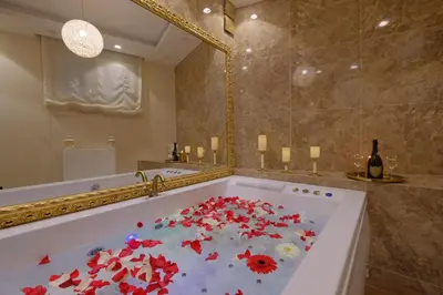 a bath tub filled with red flowers in a bathroom at Central Business Apartments Jacuzzi in Belgrade