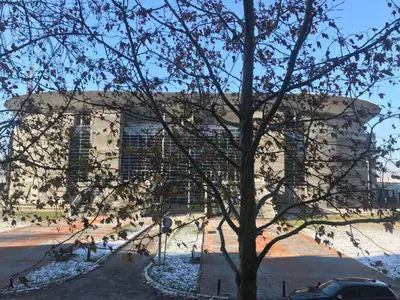 a large building with a tree in front of it at Arena East Apartment in Belgrade