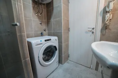 a bathroom with a washing machine and a sink at Arena East Apartment in Belgrade