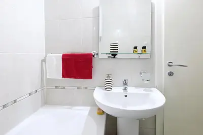 a white bathroom with a sink and a toilet at Apartment Aska in Belgrade