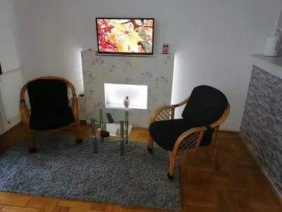 a living room with two chairs and a television at Apartment Aska in Belgrade