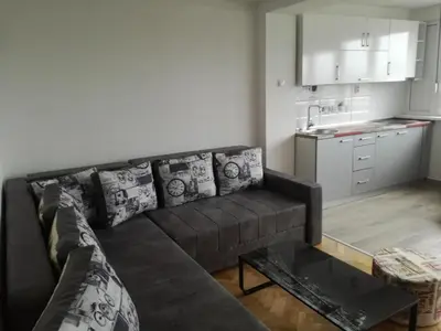 a living room with a couch and a kitchen at Penthouse Novi Beograd in Belgrade