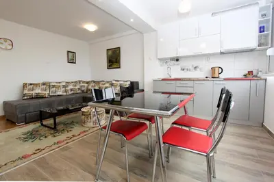 a kitchen and living room with a table and chairs at Penthouse Novi Beograd in Belgrade