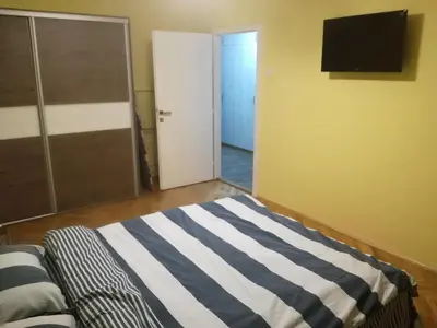 a bedroom with a bed and a television on a wall at Penthouse Novi Beograd in Belgrade