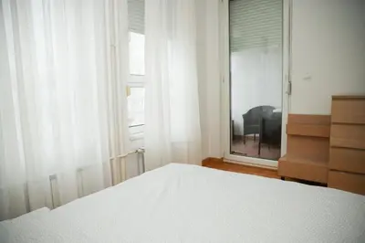 a bedroom with a bed and a dresser and a window at Apartman Green relax Belville in Belgrade