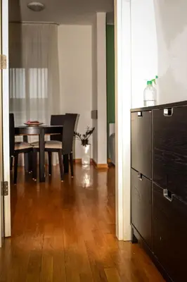 a dining room with a table and chairs and a wooden floor at Apartman Green relax Belville in Belgrade