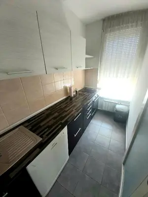 a small kitchen with white cabinets and a window at Apartman Green relax Belville in Belgrade