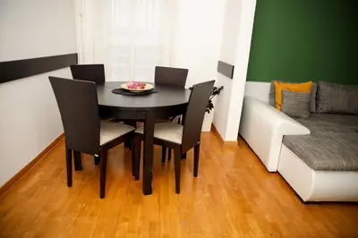a black dining room table with chairs and a couch at Apartman Green relax Belville in Belgrade