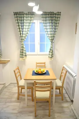 a dining room with a table and chairs and a window at Saramala Apartment in Belgrade