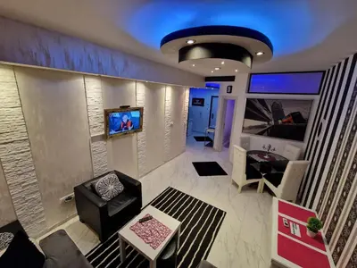 a living room with a couch and a tv on a wall at Black & White in Belgrade