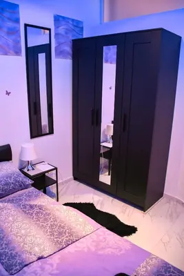a bedroom with a bed and two large mirrors at Black & White in Belgrade